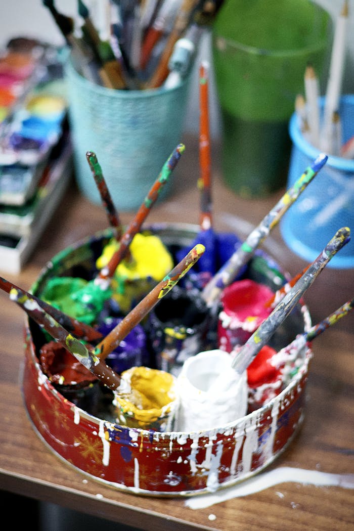 A vibrant collection of paintbrushes and paints in an artist's studio, perfect for creative inspiration.